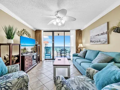 a living room with a blue couch and a tv at Summerhouse 1012C in Panama City Beach