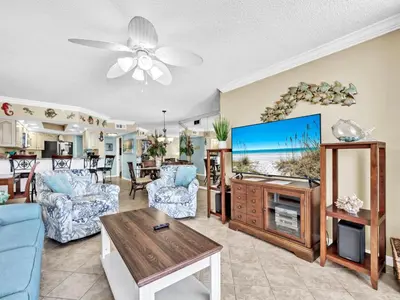 a living room with a tv and a table at Summerhouse 1012C in Panama City Beach