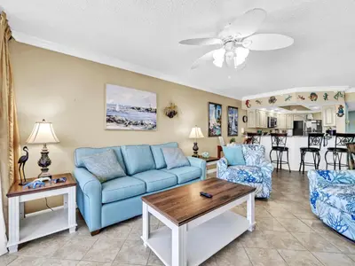 a living room with a blue couch and a table at Summerhouse 1012C in Panama City Beach