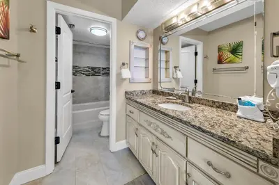 a bathroom with a sink and a toilet and a mirror at Summerhouse 1012C in Panama City Beach