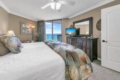 a bedroom with a large bed and a television at Summerhouse 1012C in Panama City Beach