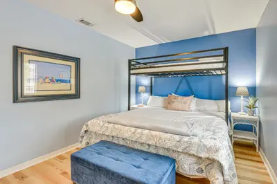 a bedroom with a bed with a blue accent wall at The Wave PCB Townhome with Pools and Beach Access in Panama City Beach
