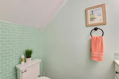 a bathroom with a toilet and a towel on the wall at The Wave PCB Townhome with Pools and Beach Access in Panama City Beach