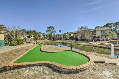 a miniature golf course with a pond and buildings at The Wave PCB Townhome with Pools and Beach Access in Panama City Beach