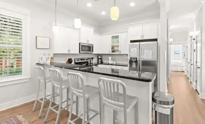 a kitchen with a bar with stools in it at 17 Trigger Trail West in Panama City