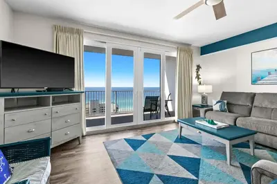 a living room with a couch and a television with the ocean at Laketown Wharf 1817 in Panama City Beach