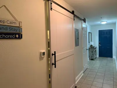 a hallway with a door and a hallway withkeep calm and stayued at Laketown Wharf 1817 in Panama City Beach