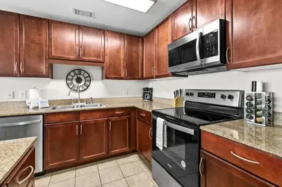 a kitchen with wooden cabinets and black appliances at Laketown Wharf 1817 in Panama City Beach