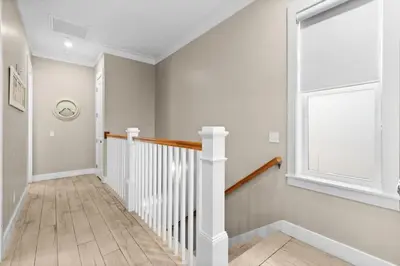 a white hallway with a staircase and a window at Blessing on the Beach in Panama City Beach