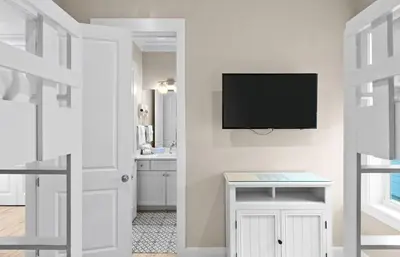 a white room with a tv on a wall at Blessing on the Beach in Panama City Beach