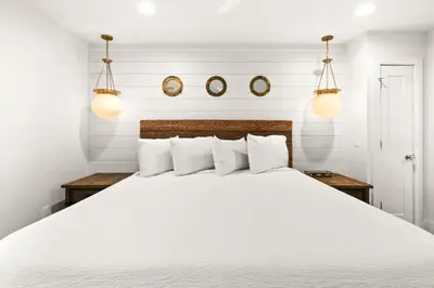 a bedroom with a large white bed with two lights at Latitude 29 Unit 21 in Panama City Beach