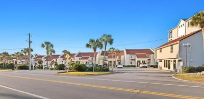 an empty street with houses and palm trees at Latitude 29 Unit 21 in Panama City Beach