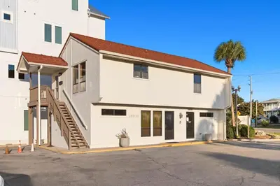 a white house with a staircase next to a building at Latitude 29 Unit 21 in Panama City Beach