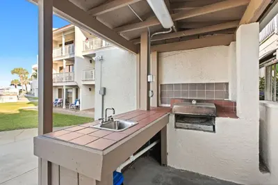 a outdoor kitchen with a sink and a grill at Latitude 29 Unit 21 in Panama City Beach