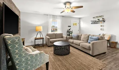 a living room with couches and a ceiling fan at Sandy Feet Escape in Panama City Beach