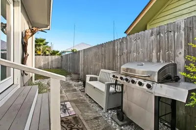 a grill on a patio next to a fence at Sandy Feet Escape in Panama City Beach