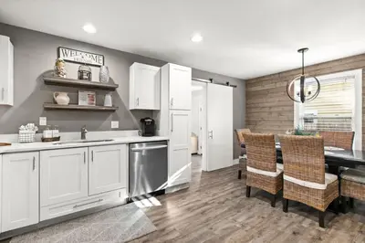 a kitchen with white cabinets and a table and chairs at Sandy Feet Escape in Panama City Beach
