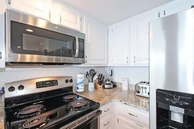 a kitchen with a black stove and a microwave at One Seagrove Place 0601 in Santa Rosa Beach