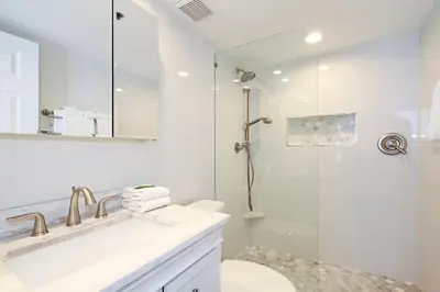 a white bathroom with a shower and a sink at One Seagrove Place 0601 in Santa Rosa Beach