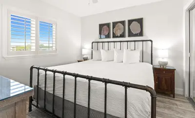 a bedroom with a bed and two windows at One Seagrove Place 0601 in Santa Rosa Beach