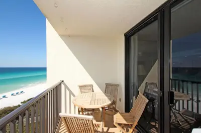 a balcony with a table and chairs and the beach at One Seagrove Place 0601 in Santa Rosa Beach