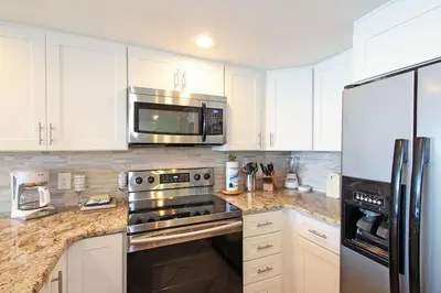 a kitchen with stainless steel appliances and white cabinets at One Seagrove Place 0605 in Santa Rosa Beach