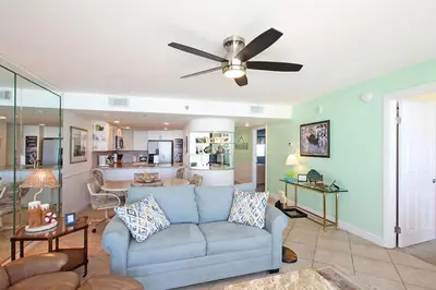 a living room with a blue couch and a ceiling fan at One Seagrove Place 0605 in Santa Rosa Beach