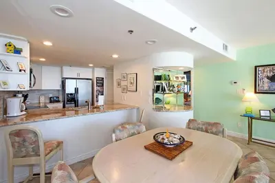 a dining room with a table and a kitchen at One Seagrove Place 0605 in Santa Rosa Beach