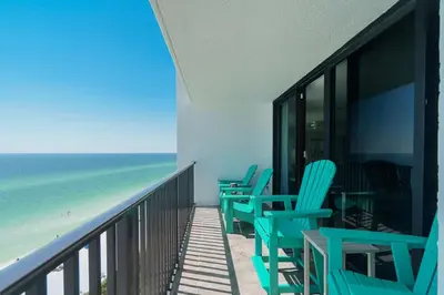 a balcony with blue chairs and the beach at One Seagrove Place 1101 in Santa Rosa Beach