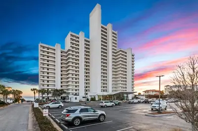 a large white building with cars parked in a parking lot at One Seagrove Place 0608 in Santa Rosa Beach