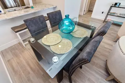 a glass table with a blue vase on top of it at One Seagrove Place 0806 in Santa Rosa Beach