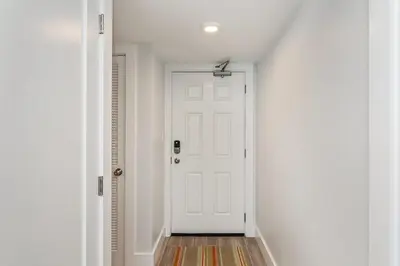 a hallway with a white door and a wooden floor at One Seagrove Place 0806 in Santa Rosa Beach