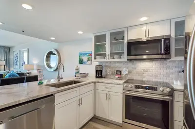 a kitchen with white cabinets and stainless steel appliances at One Seagrove Place 0806 in Santa Rosa Beach