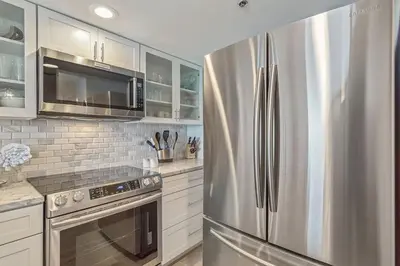 a kitchen with a stainless steel refrigerator and microwave at One Seagrove Place 0806 in Santa Rosa Beach