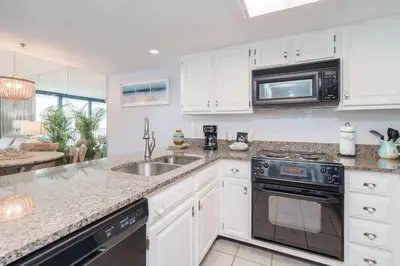 a kitchen with white cabinets and a sink at One Seagrove Place 0501 in Santa Rosa Beach