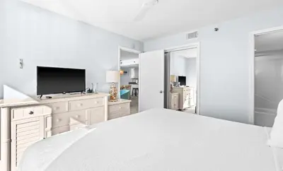 a white bedroom with a large bed and a flat screen tv at One Seagrove Place 0501 in Santa Rosa Beach