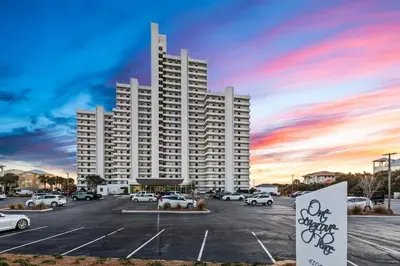 a large white building with cars parked in a parking lot at One Seagrove Place 0701 in Santa Rosa Beach