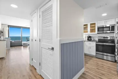 a kitchen with white cabinets and a view of the ocean at One Seagrove Place 0802 in Santa Rosa Beach