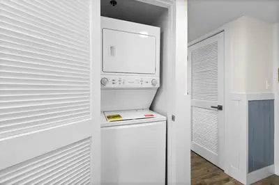 a white refrigerator in a kitchen with a microwave at One Seagrove Place 0802 in Santa Rosa Beach