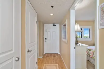 a hallway with a white door and a bedroom at One Seagrove Place 1007 in Santa Rosa Beach