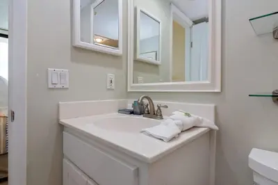 a white bathroom with a sink and a mirror at One Seagrove Place 1007 in Santa Rosa Beach