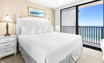 a bedroom with a white bed and a balcony at One Seagrove Place 1007 in Santa Rosa Beach
