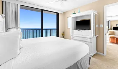 a bedroom with a white bed and a television at One Seagrove Place 1007 in Santa Rosa Beach