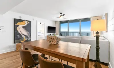 a living room with a table and a couch at One Seagrove Place 0906 in Santa Rosa Beach