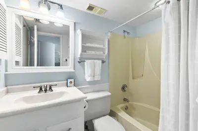 a bathroom with a sink and a toilet and a mirror at One Seagrove Place 1103 in Santa Rosa Beach