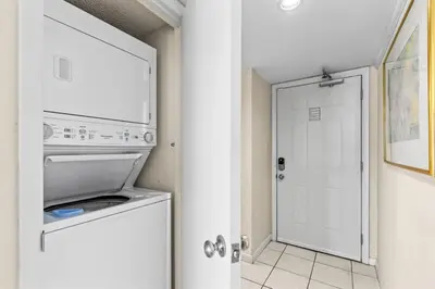 a kitchen with a white refrigerator and a white door at One Seagrove Place 1103 in Santa Rosa Beach
