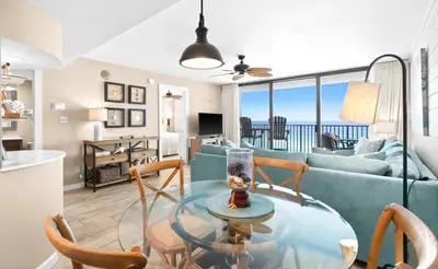 a living room with a glass table and chairs at One Seagrove Place 1004 in Santa Rosa Beach