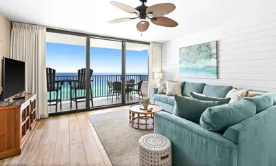 a living room with a blue couch and a view of the ocean at One Seagrove Place 1004 in Santa Rosa Beach