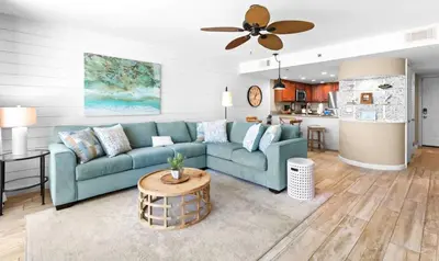 a living room with a blue couch and a kitchen at One Seagrove Place 1004 in Santa Rosa Beach
