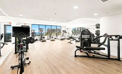 a gym with several tread machines and a flat screen tv at One Seagrove Place 1004 in Santa Rosa Beach